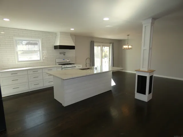 a kitchen with stainless steel appliances a stove refrigerator sink and cabinets