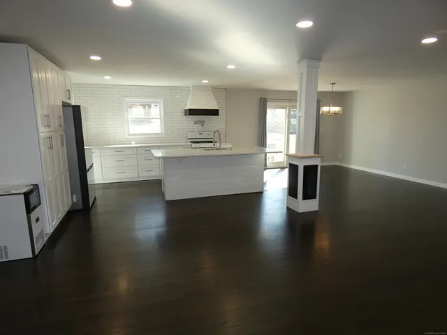 a view of kitchen with sink and refrigerator