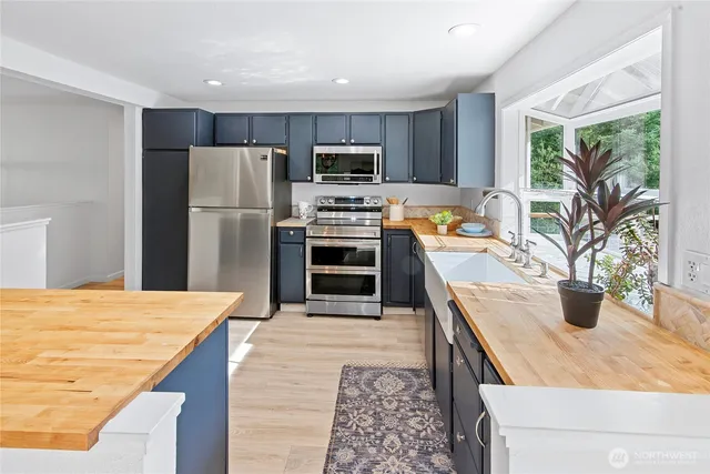 a kitchen with stainless steel appliances granite countertop a sink stove microwave and refrigerator