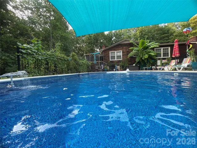 a view of a house with a swimming pool and sitting area