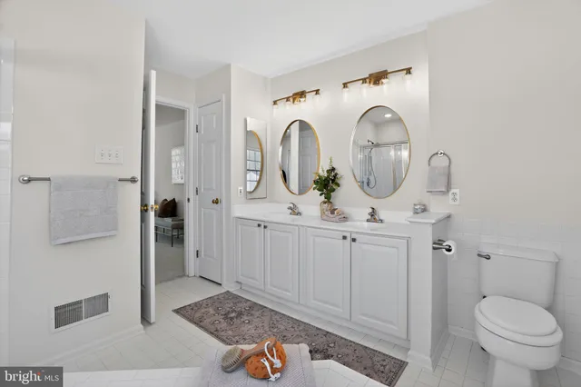 a bathroom with sink a mirror a toilet and a shower