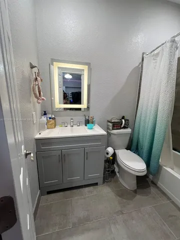 a bathroom with a sink vanity mirror and toilet