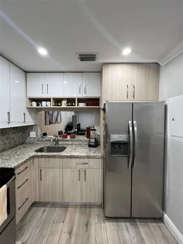 a kitchen with a refrigerator sink and cabinets