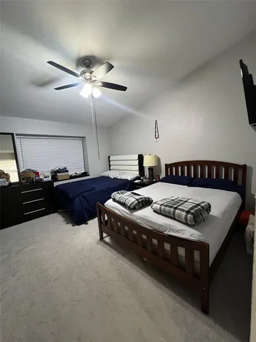 a spacious bedroom with a bed and a chandelier