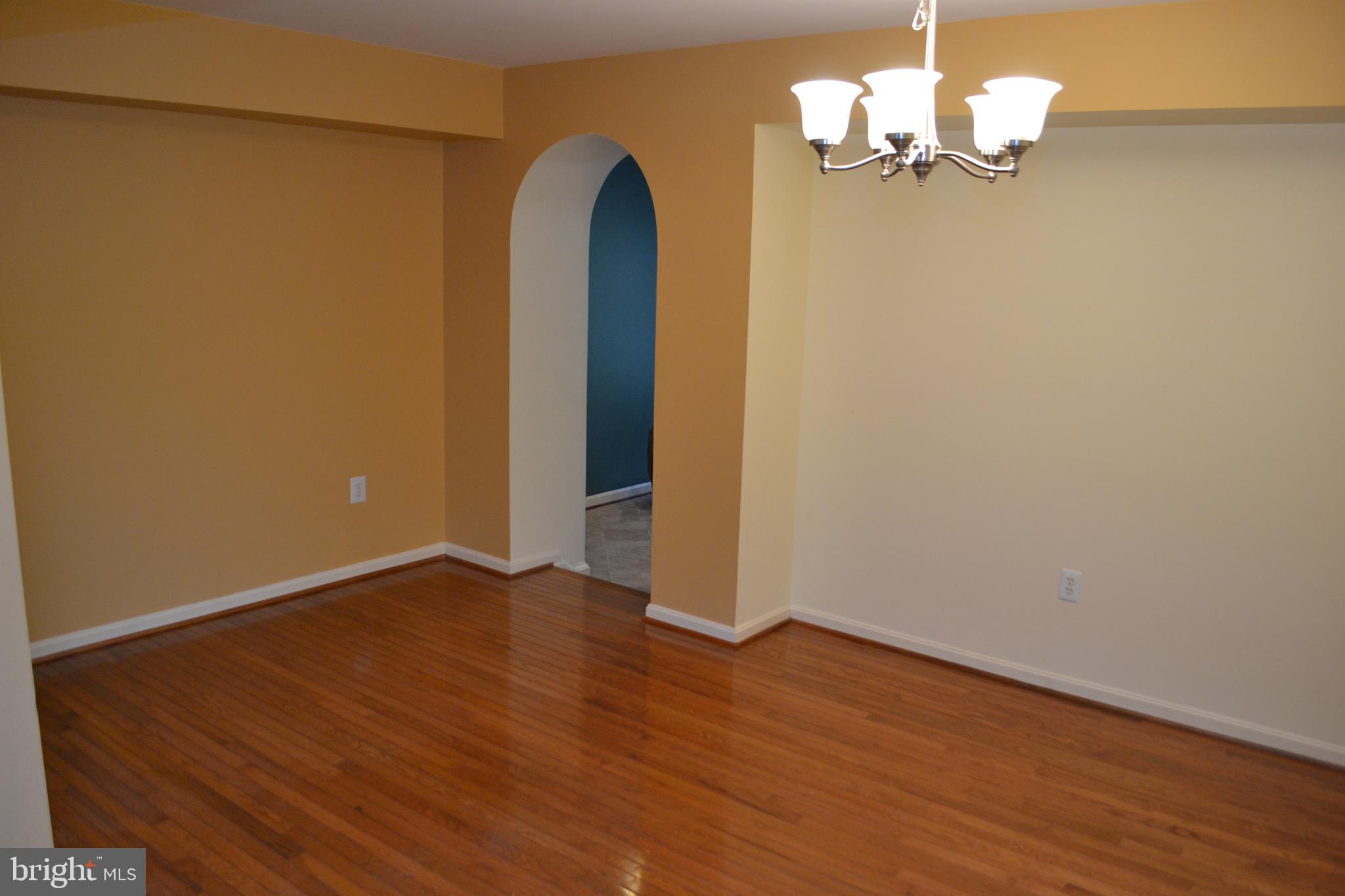 2202 Garden Lane Frederick, MD 21701 - Photo 9 of 50 an empty room with wooden floor chandelier and windows