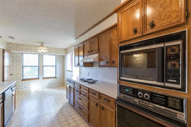 a kitchen with stainless steel appliances granite countertop a stove and a microwave