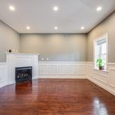 a view of empty room with wooden floor and fireplace