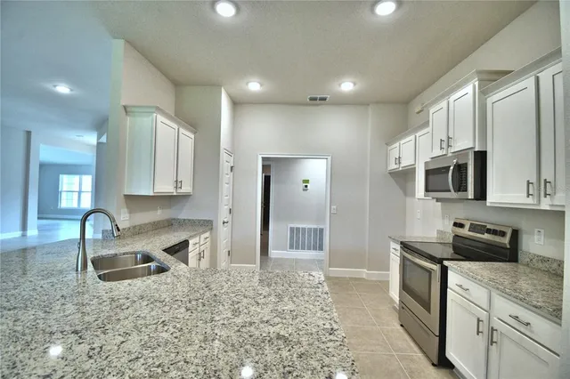 a bathroom with a granite countertop sink a toilet and shower
