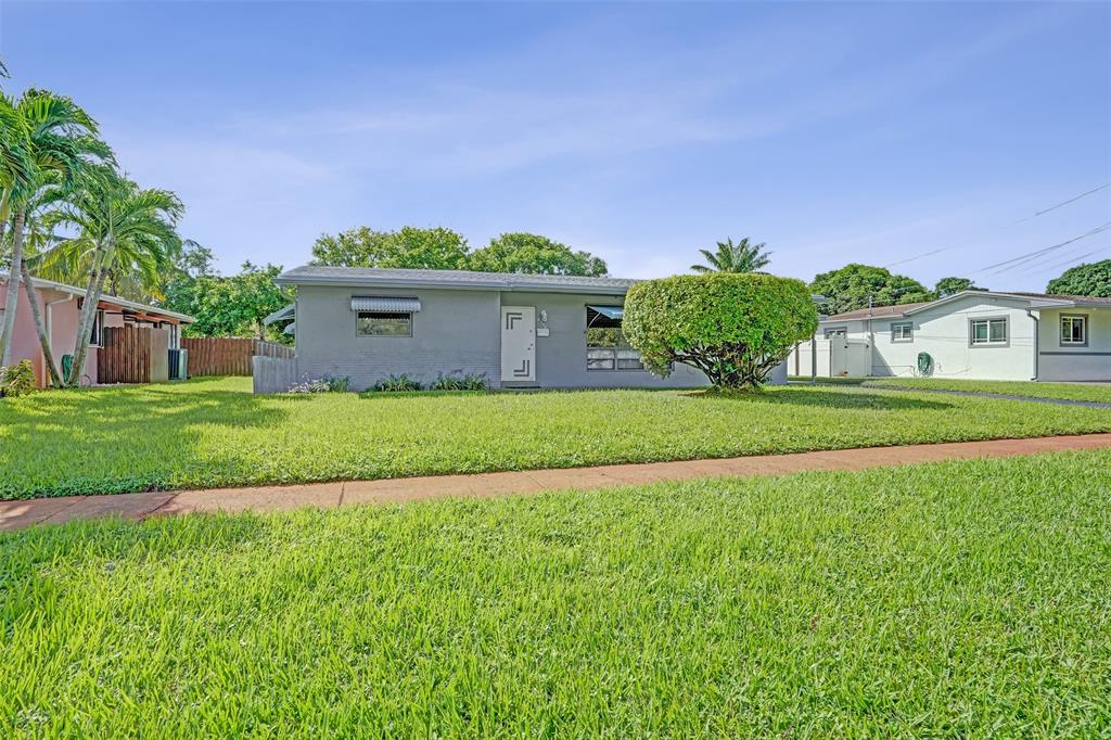 4738 Northwest 5th Street Plantation, FL 33317 - Photo 3 of 68 a front view of a house with a yard and garage