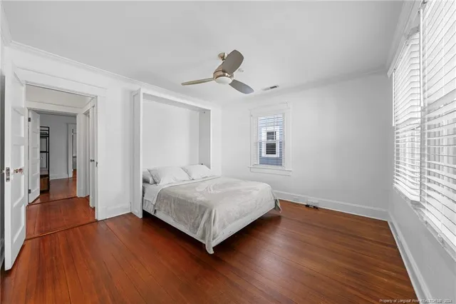 a bedroom with a bed and wooden floor