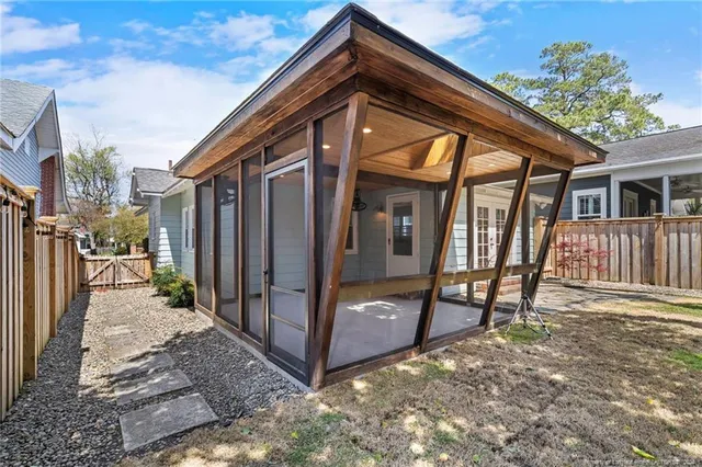 a view of backyard with wooden fence and large trees