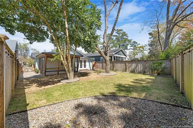 a view of a house with backyard and a tree