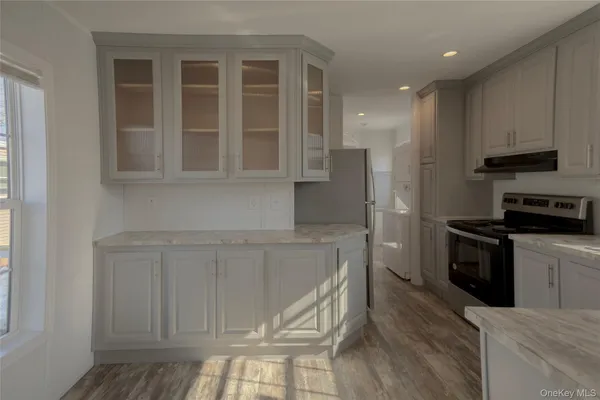 a kitchen with stainless steel appliances granite countertop a stove a sink and a refrigerator