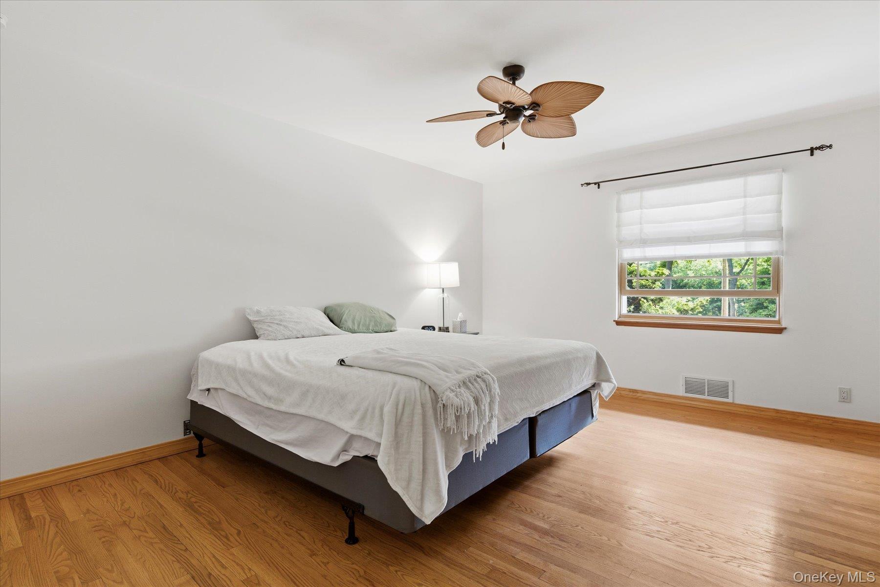 42 Cliff Road Port Jefferson, NY 11777 - Photo 18 of 22 a bedroom with a bed and a chandelier
