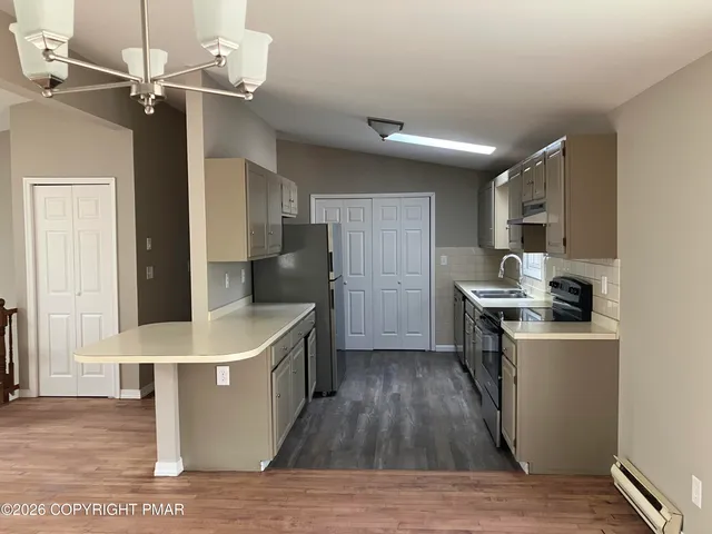 a kitchen with granite countertop a sink appliances and cabinets