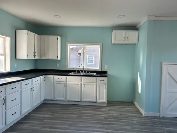 a kitchen with granite countertop white cabinets and a stove