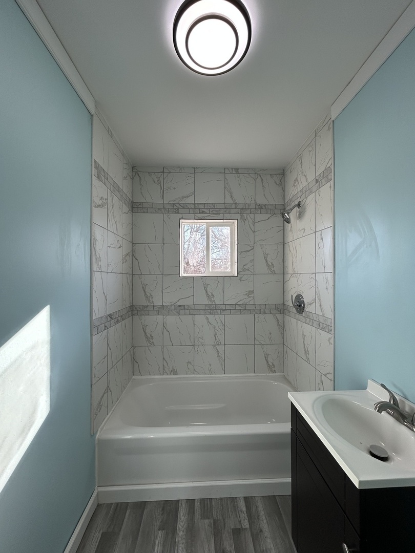 129 West Main Street Amboy, IL 61310 - Photo 23 of 40 a bathroom with a tub a sink and a shower