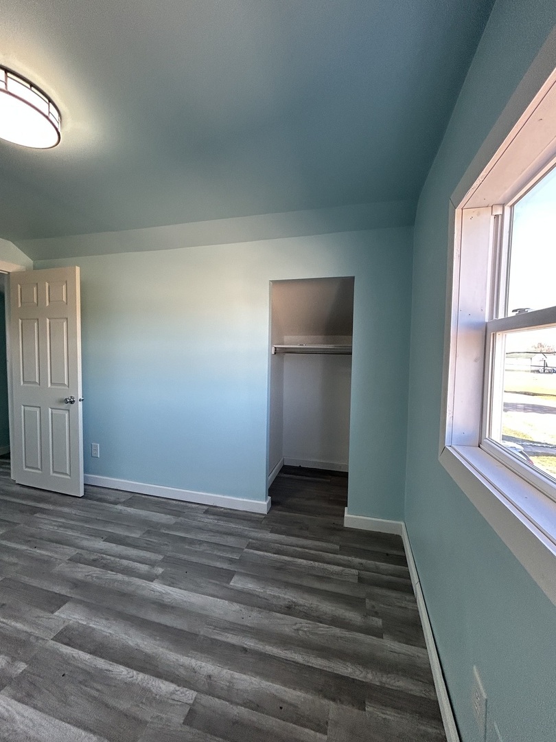 129 West Main Street Amboy, IL 61310 - Photo 28 of 40 a view of an empty room with wooden floor and a window