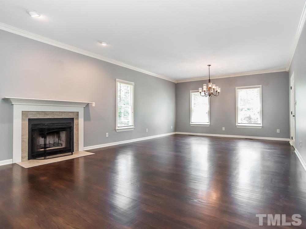 3608 Willow Bluff Drive Raleigh, NC 27604 - Photo 11 of 29 an empty room with wooden floor fireplace and windows