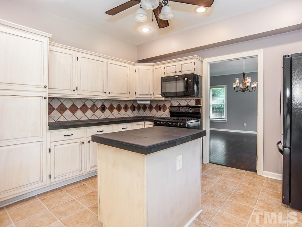 3608 Willow Bluff Drive Raleigh, NC 27604 - Photo 12 of 29 a kitchen with kitchen island white cabinets and refrigerator