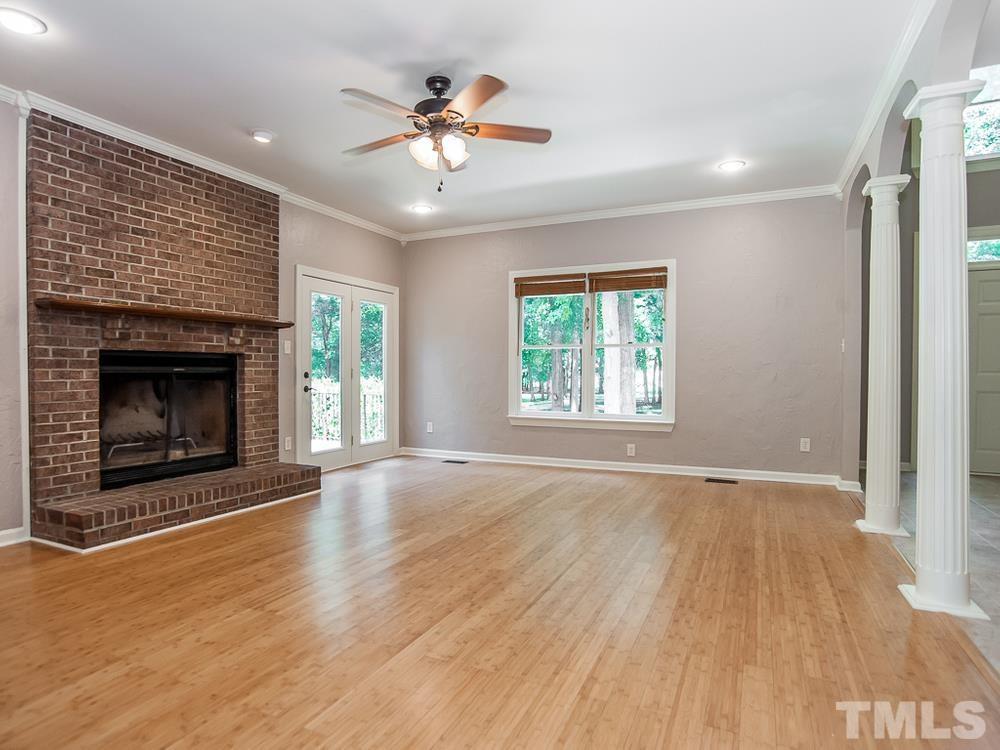 3608 Willow Bluff Drive Raleigh, NC 27604 - Photo 14 of 29 an empty room with windows fireplace and wooden floor