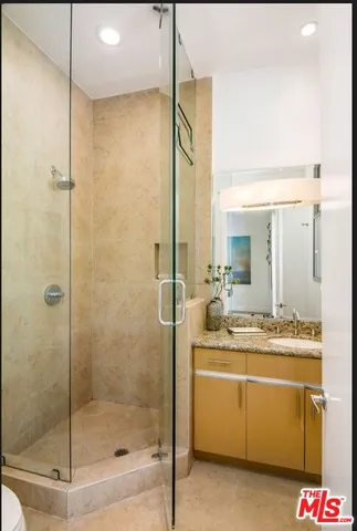 a bathroom with a shower sink and mirror
