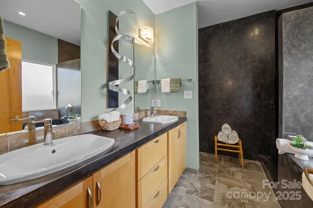 a en suite bathroom with a double vanity sink and a mirror