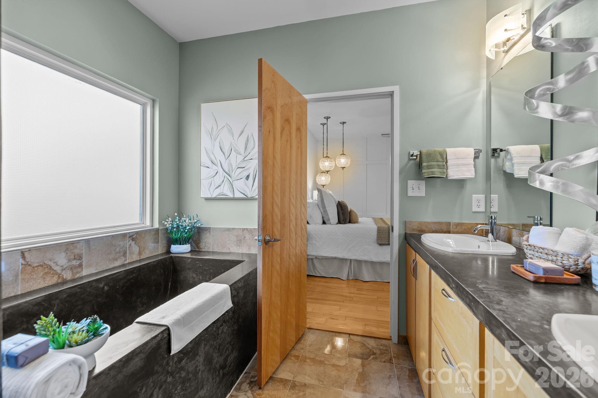 3534 Card Street Charlotte, NC 28205 - Photo 13 of 24 a bathroom with a granite countertop tub a double vanity sink and mirror