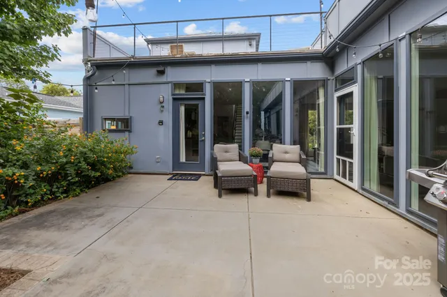 a patio with a table and chairs and potted plants
