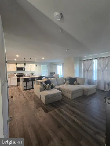 a living room with furniture and kitchen view