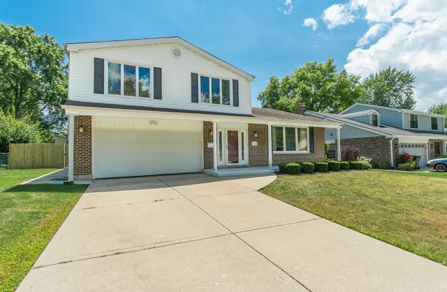 a front view of a house with a yard and trees