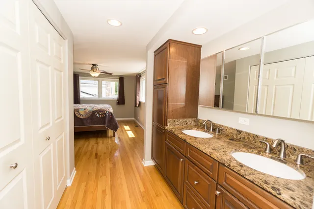 a en suite bathroom with a granite countertop double vanity sink and a mirror