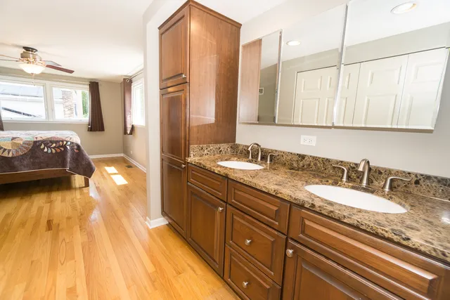 a view of a bedroom with wooden floor and a ceiling fan