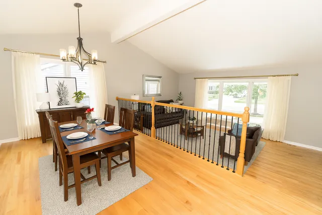 a dining room with furniture a chandelier and wooden floor