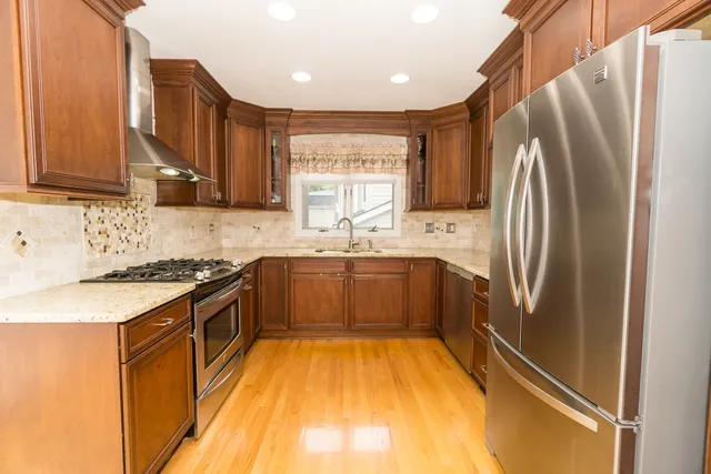 a kitchen with stainless steel appliances granite countertop a refrigerator sink and stove