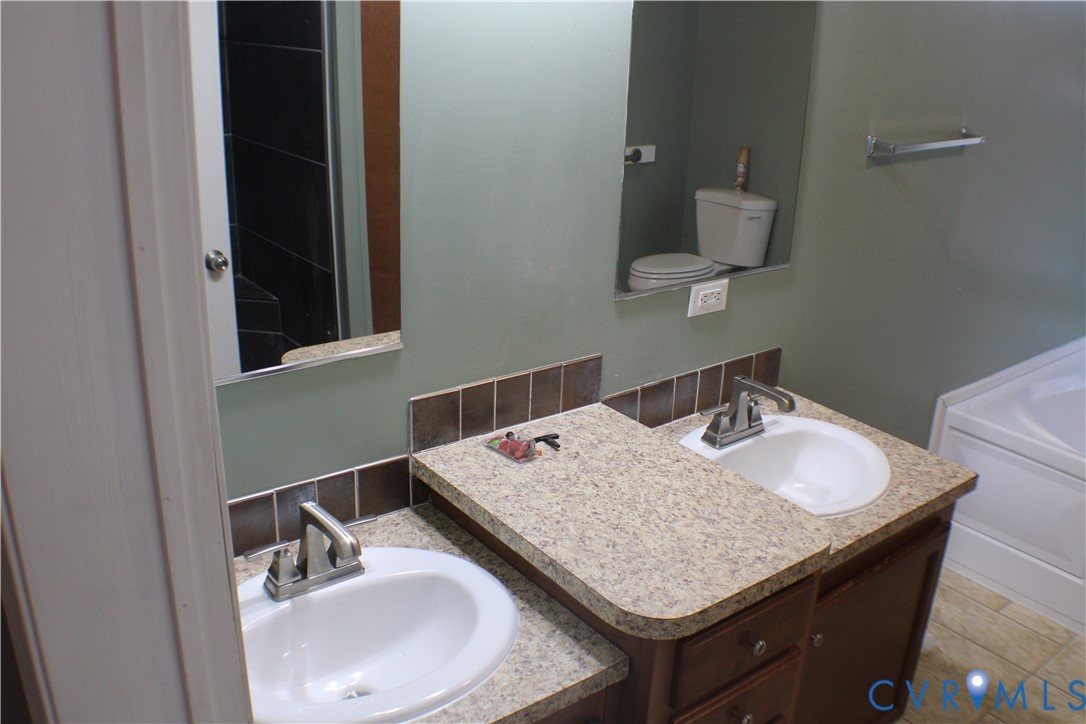 1811 Halls Store Road Mineral, VA 23117 - Photo 28 of 39 Bathroom with backsplash, vanity, and a tub to rel