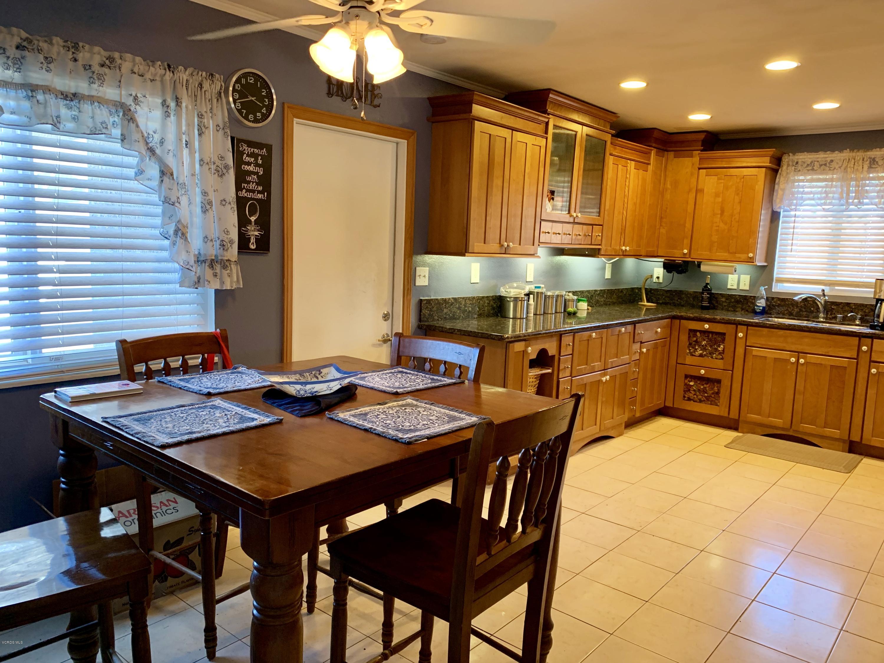 2890 Fitzgerald Road Simi Valley, CA 93065 - Photo 11 of 40 a kitchen with stainless steel appliances granite countertop a stove a sink dishwasher a dining table and chairs with wooden floor