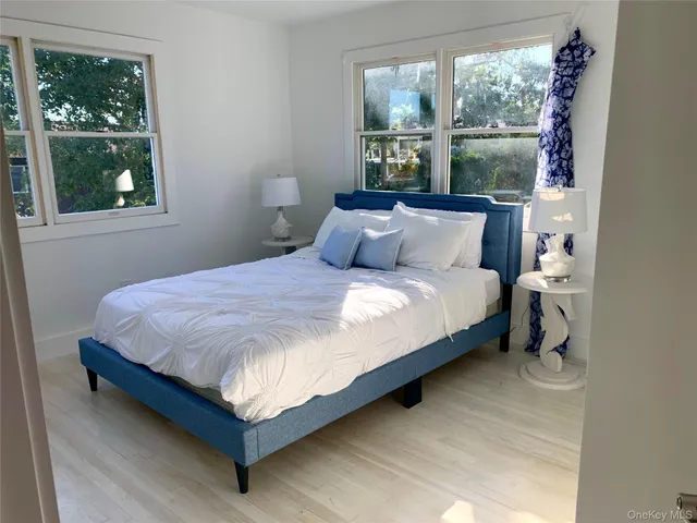 a large bed sitting in a bedroom next to a window
