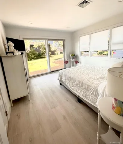 a spacious bedroom with a bed and a large window