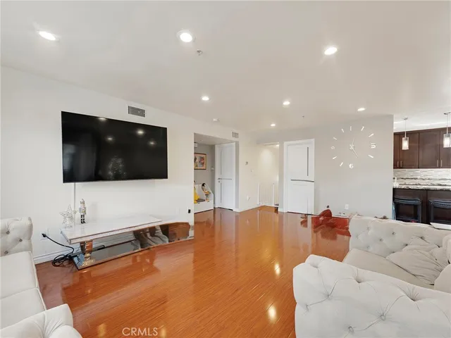 a living room with stainless steel appliances kitchen island granite countertop furniture and a refrigerator