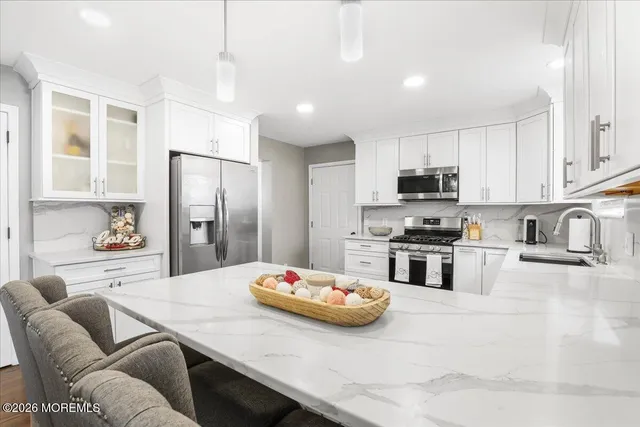 a kitchen with stainless steel appliances kitchen island granite countertop a kitchen island and chairs