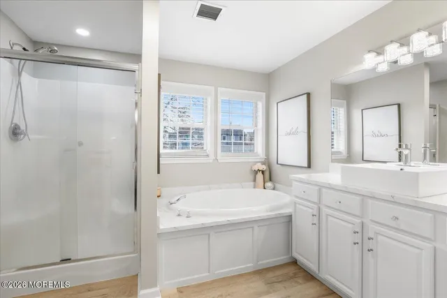 a bathroom with a tub a sink and mirror