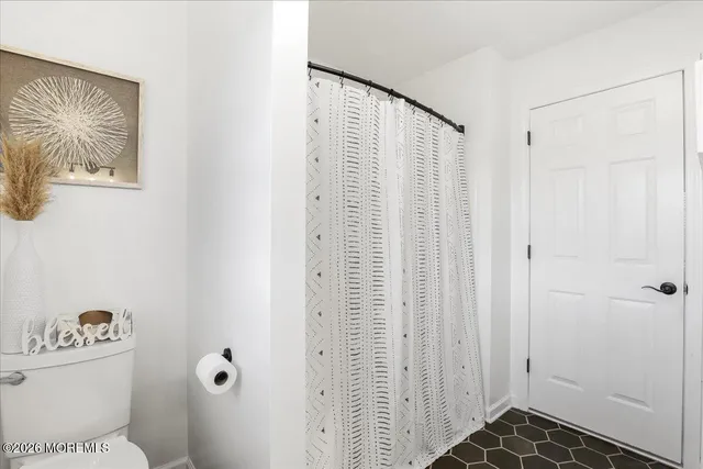 a bathroom with a toilet and a shower