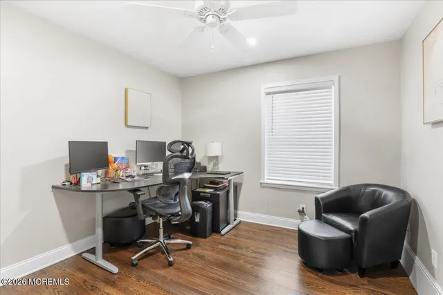 a view of a workspace with furniture and a window