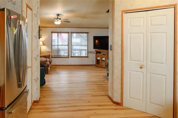 a view of a hallway with wooden floor and a living room