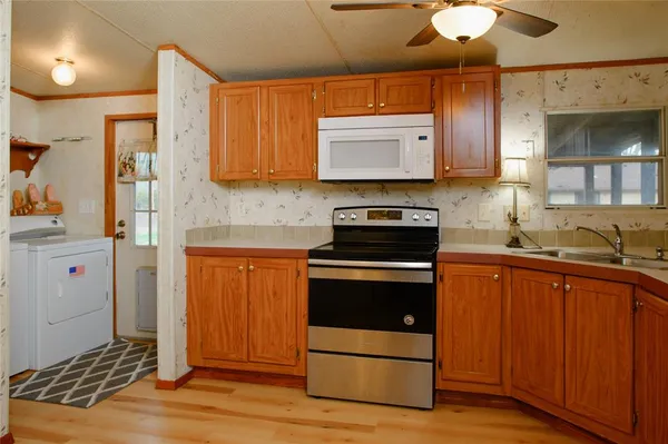 a kitchen with stainless steel appliances granite countertop wooden cabinets a stove a sink and a refrigerator