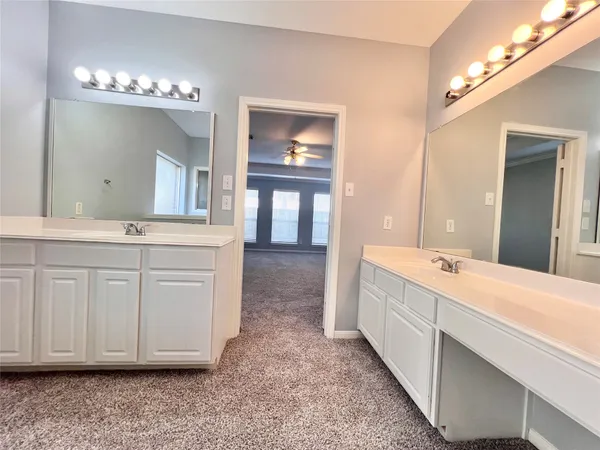 an empty room with wooden floor fan and window