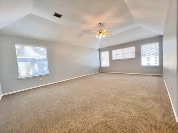 a view of a room with wooden floor and a ceiling fan
