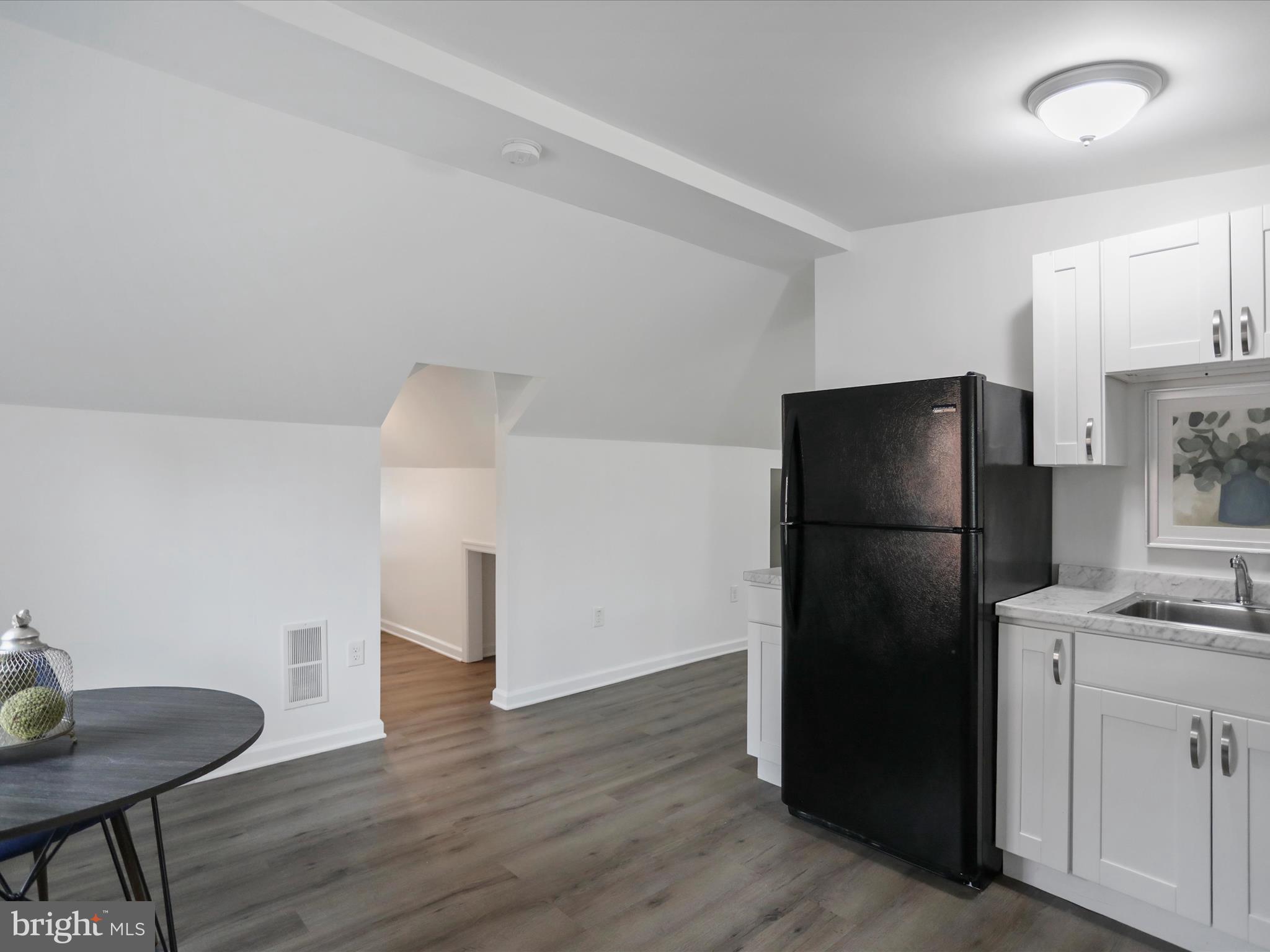 102 Frederick Avenue Frederick, MD 21701 - Photo 25 of 55 a kitchen with a refrigerator cabinet and a table