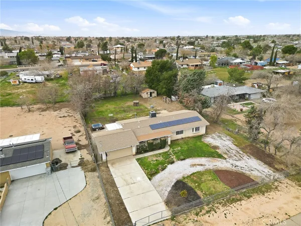 an aerial view of a house with a yard and pool